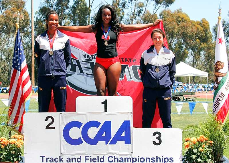 Lauren McGlory, center, after placing first at Track and Field Championships.