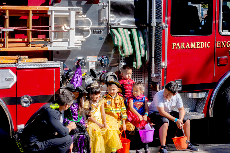 A+Hayward+Firefighter+gets+ready+to+take+a+picture+with+a+group+of+kids+dressed+for+the+occasion.