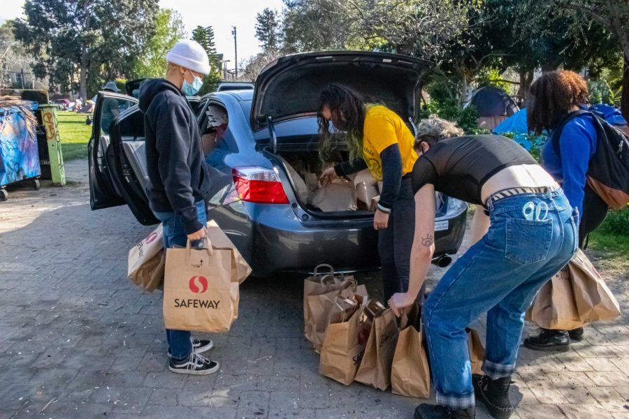Local volunteers begin unpacking food for the houseless living at People’s Park in Berkeley, California, on March 5. The event was put on by the Liberated Lens Film Collective, Food Not Bombs, and National Public Housing Museum in collaboration with Omni Commons, a community event space.
