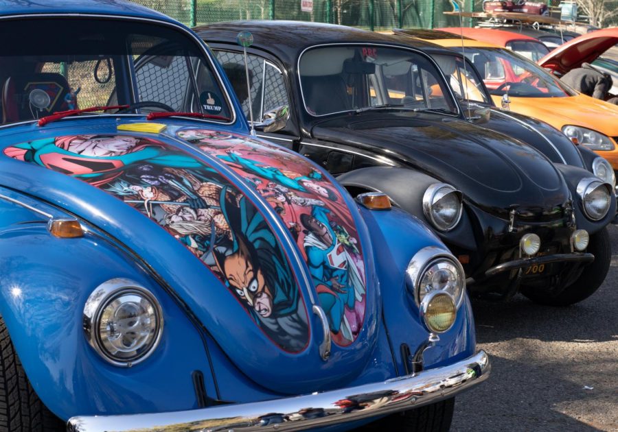 These buggies are one of a kind. The blue Volkswagen (VW) Beetle on the left totes a hand-painted cartoon design of famous characters on its hood along with multiple other unique customizations.