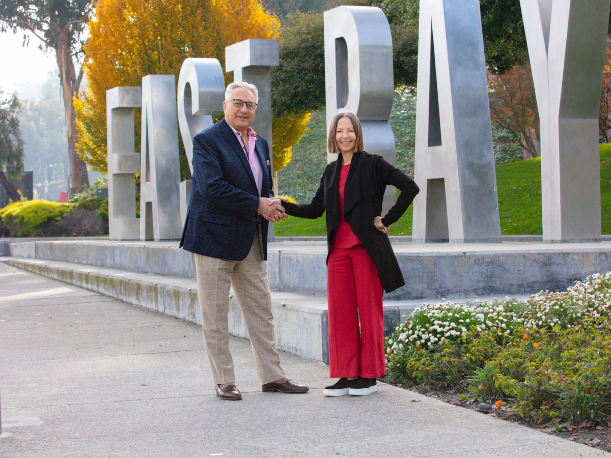 Life West President Peter J. Kevorkian (left), and CSUEB President Cathy Sandeen (right), commemorate the partnership between their respective universities with a handshake. 