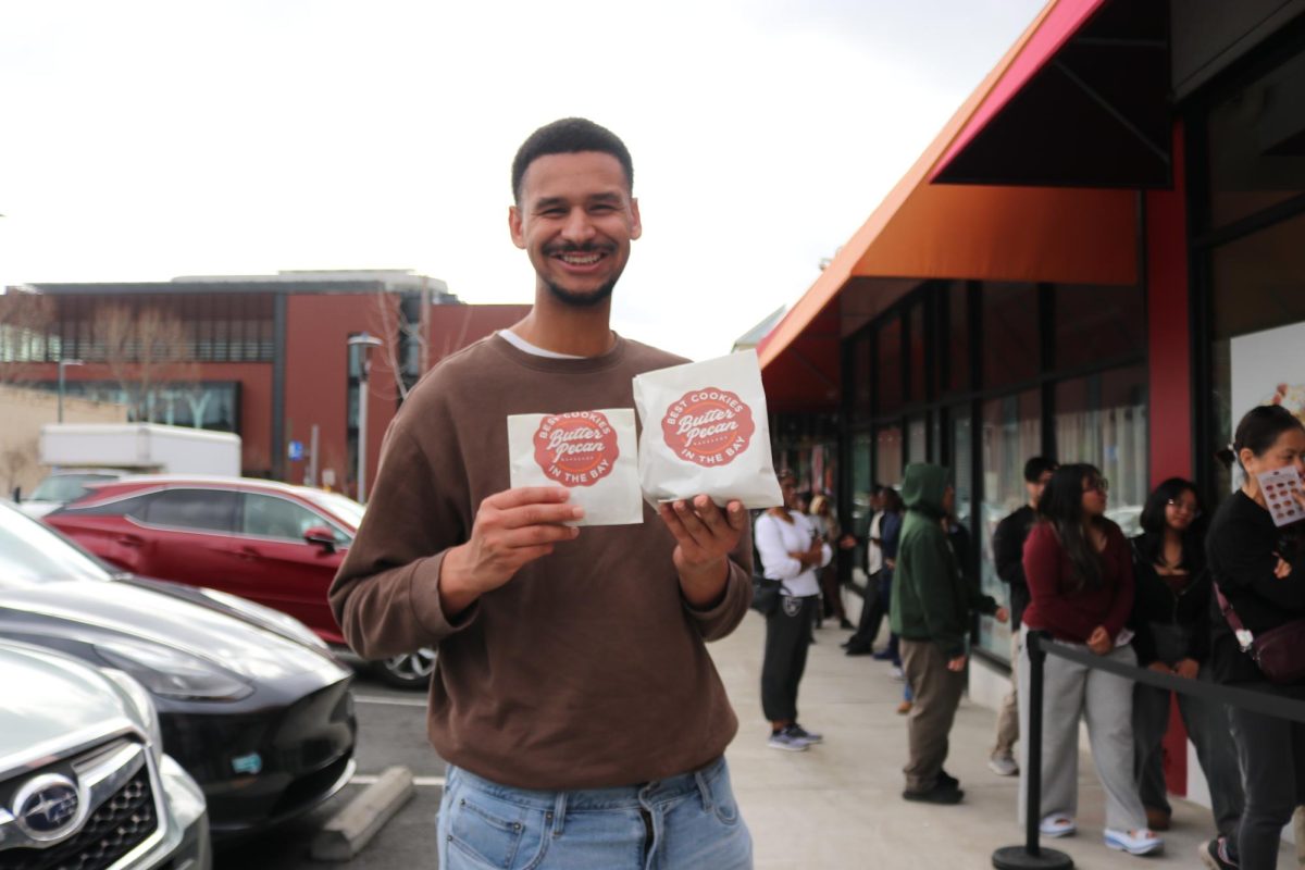 Hayward resident Paxton Churchwell purchases cookies and cream-flavored cookies, and receives a free treat as part of Butter Pecan Bakeshop’s opening promotion.