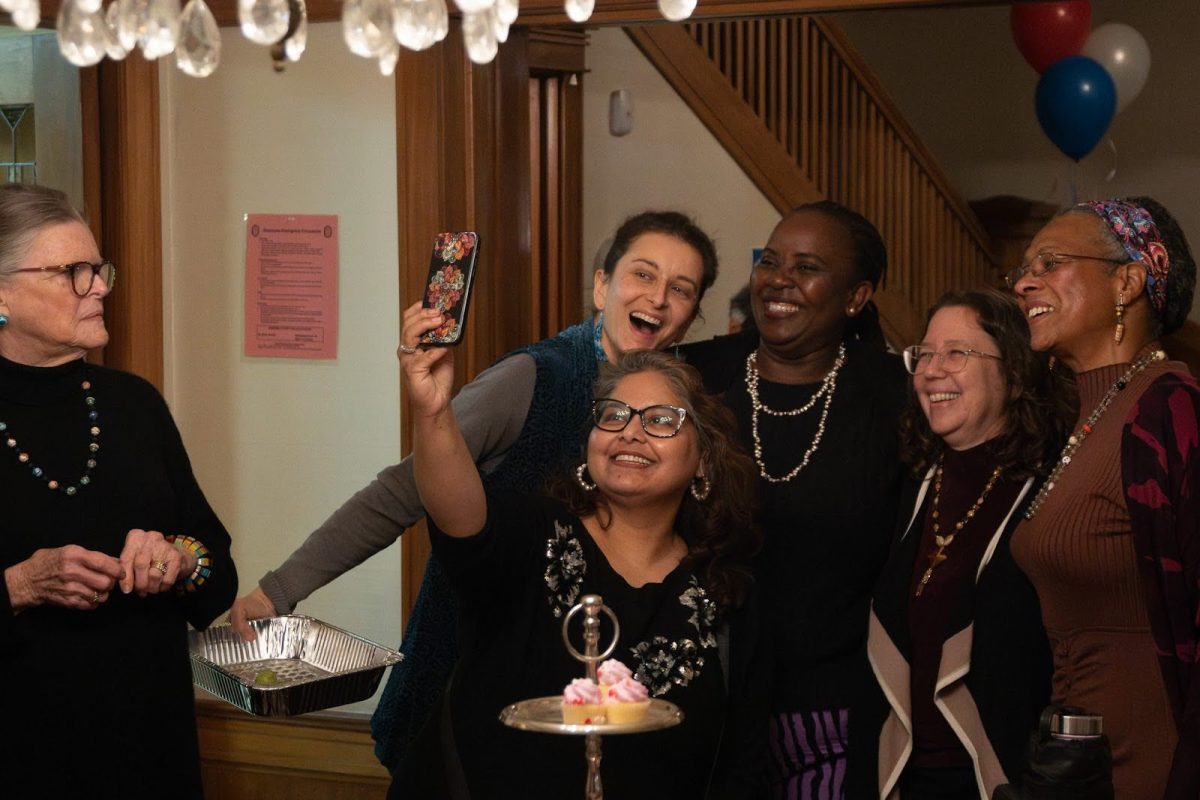  Roxanne Lewis (left) looks on as Vrushali Nanjundappa (center bottom) captures a group selfie with Liz Nelson, Shubbie Aishida,  President Sara Lamnin, Velda Go (left to right) during the LWVEA Birthday Bash.