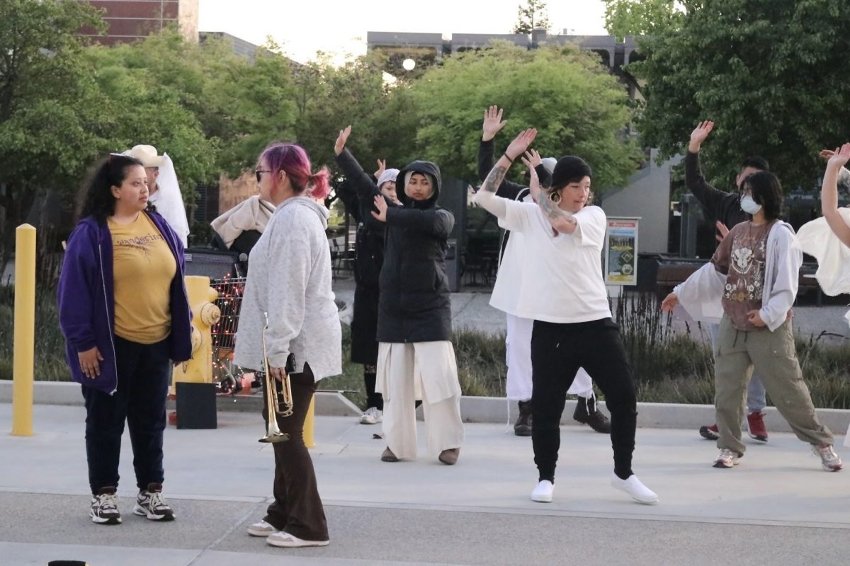 Bea Aguirre (center) plays Rust, a hearer confused about her ability to communicate with spirits. In this scene, she is mentored by fellow hearer Storm, played by Jasmine Guerrero (left), as spirits dance in the background.