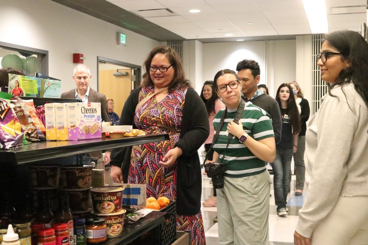 CSUEB community members admire the variety of pantry food items available at the WellNest, located in Room 102 of the North University Union. 